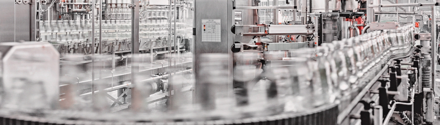 Automatisierte Verpackungsanlage mit Fördertechnik und Glasflaschen in einer industriellen Produktionsumgebung